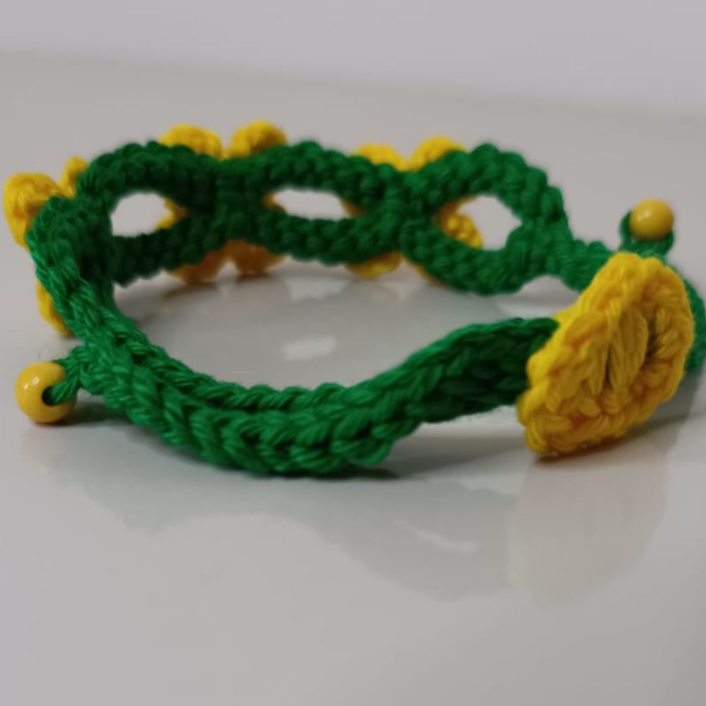 Pulseira Brasil em Flor em Crochê Artesanal 3 Pulseira Brasil em Flor em crochê artesanal nas cores verde e amarelo, com flores delicadas e detalhes em pérolas.