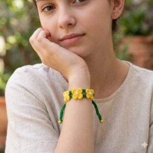 Pulseira Brasil em Flor em crochê artesanal nas cores verde e amarelo, com flores delicadas e detalhes em pérolas.