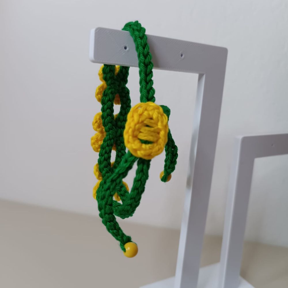 Pulseira Brasil em Flor em Crochê Artesanal 6 Pulseira Brasil em Flor em crochê artesanal nas cores verde e amarelo, com flores delicadas e detalhes em pérolas.