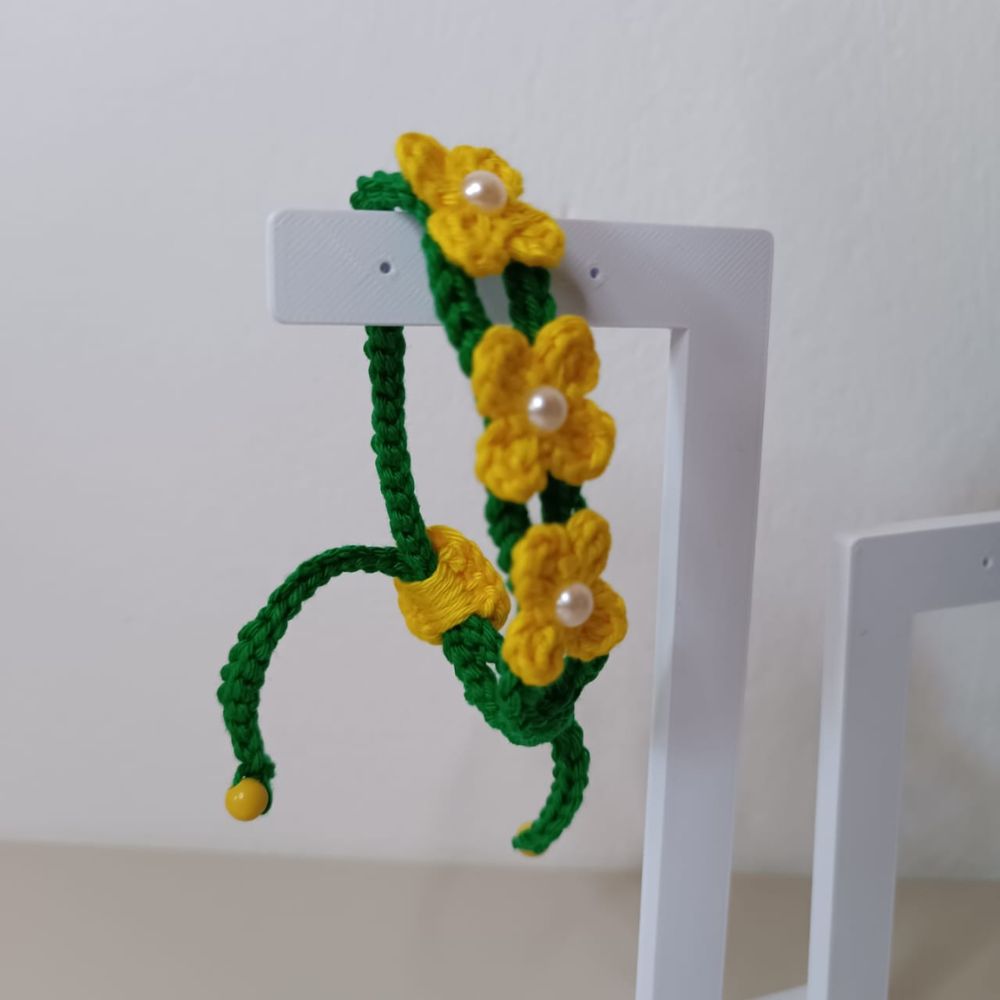 Pulseira Brasil em Flor em Crochê Artesanal 5 Pulseira Brasil em Flor em crochê artesanal nas cores verde e amarelo, com flores delicadas e detalhes em pérolas.